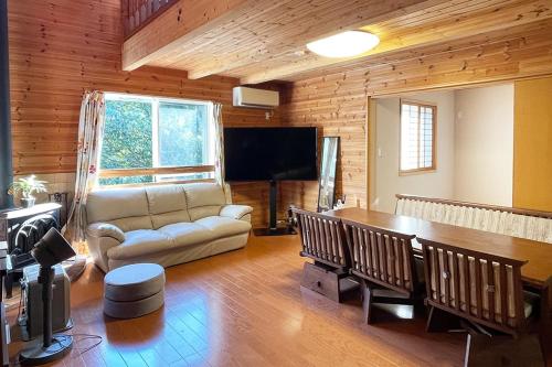 a living room with a couch and a table at るり渓フォレストコテージｂ-9号棟樋口邸 in Nantan city
