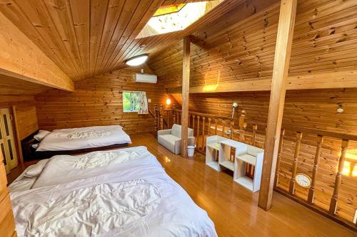 a bedroom with two beds in a wooden cabin at るり渓フォレストコテージｂ-9号棟樋口邸 in Nantan city