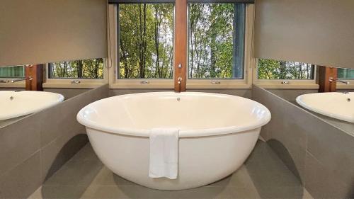 a large white tub in a bathroom with two sinks at The Studio Suite at Villa 7 in Hepburn Springs