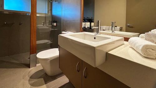 a bathroom with a sink and a toilet and a shower at The Studio Suite at Villa 7 in Hepburn Springs