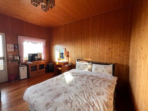 a bedroom with a bed and a wooden wall at Ming Zhen Homestay in Gukeng