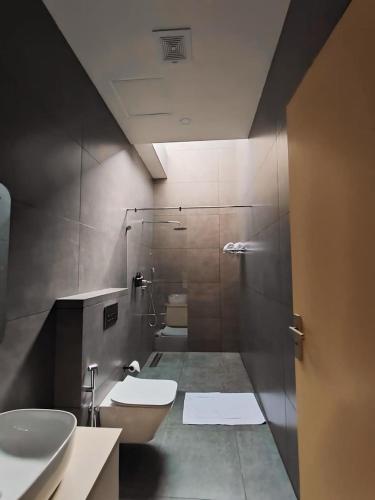 a bathroom with two sinks and a toilet and a shower at Vaigayi Ayurveda and Yoga Resort in Kodanad