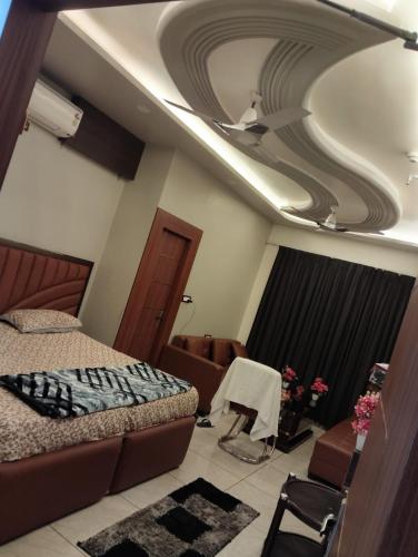un dormitorio con una cama y un sofá en una habitación en Hotel maya's, en Bāghpat