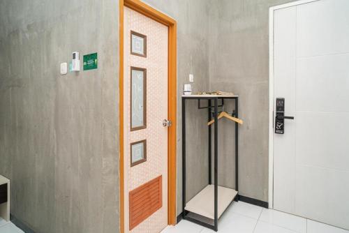 a bathroom with a shower and a door at RedDoorz Syariah At Mitra Guest House in Malang