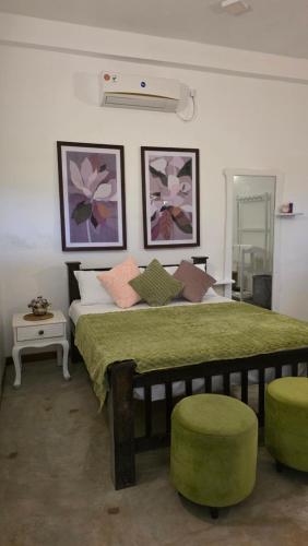 a bedroom with a large bed with a green comforter at Villa De'YuLee in Negombo