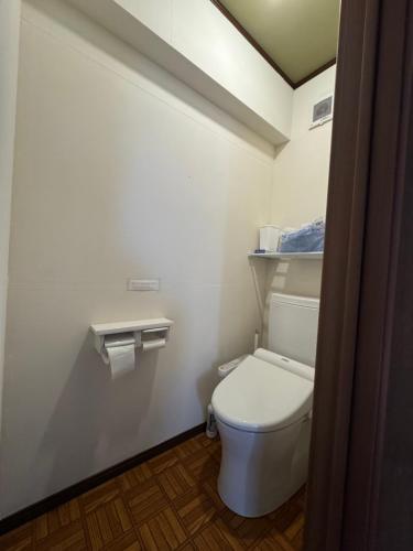 a bathroom with a white toilet in a room at ゲストハウスルスティゲス in Kijimadaira
