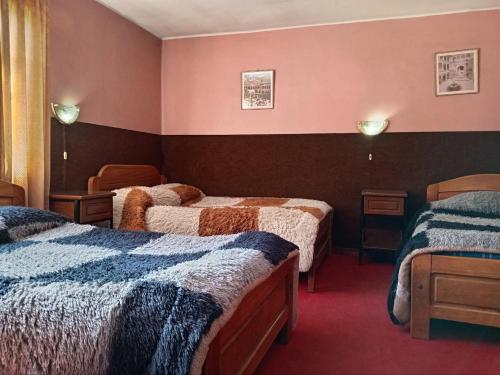 a hotel room with three beds in a room at Hostal Tambo de Oro in La Paz