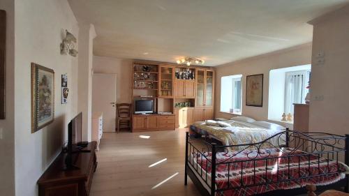 a bedroom with a bed and a living room at B&B Al Larice in Strigno