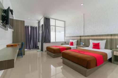 a hotel room with two beds and a television at RedDoorz Plus @ Vantas Hotel Parbaba in Sinapuran
