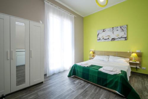 a bedroom with a bed with a green wall at Le Cupole Design in Palermo