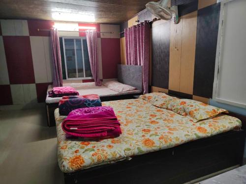 a room with two beds and a mirror at Swaroop Ashray Homestay in Siliguri