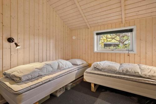 zwei Betten in einem Zimmer mit Fenster in der Unterkunft SL353 Slagelse - Dompapvej 3 in Lille Kongsmark