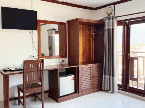 a room with a desk and a mirror and a chair at Vang Vieng Sisavang Hotel in Vang Vieng