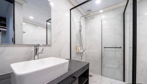 a bathroom with a white sink and a shower at 부산파크호텔 in Busan