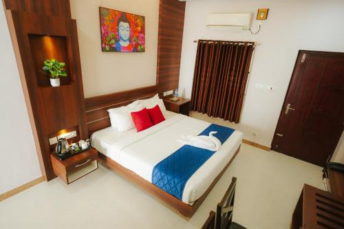 a bedroom with a bed with red and blue pillows at Dreamland View Resort in Cochin
