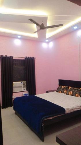a bedroom with a bed and a ceiling fan at Laxminarayan Sadan in Ayodhya