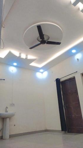 a ceiling fan in a room with a sink at Laxminarayan Sadan in Ayodhya