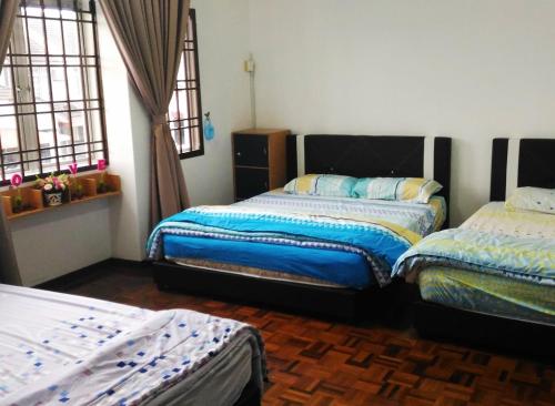 a bedroom with two beds and two windows at Home2u T'Castle in Johor Bahru