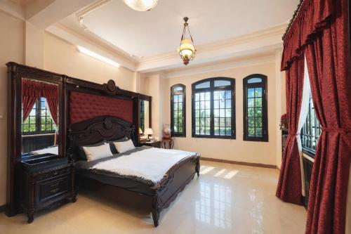 a bedroom with a bed in a room with windows at Perfume Homestay Huế in Hue