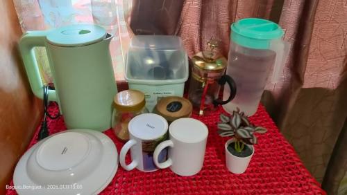 a table with cups and other items on it at Kochimoto Homestay in Baguio