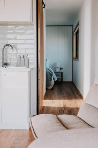a kitchen with a sink and a room with a bed at 3 Acres by the Moyne in Port Fairy