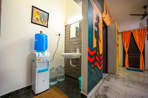 a bathroom with a refrigerator next to a sink at Rayzen Stays & Backpackers Hostel in Chennai