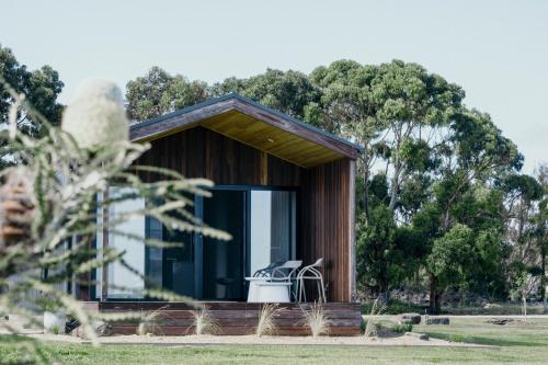 a small house with a window and a white chair in it at 3 Acres by the Moyne in Port Fairy
