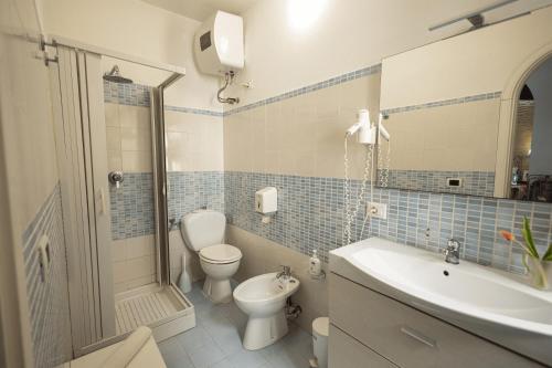 a bathroom with a toilet and a sink and a shower at Syrakosia a Ortigia in Syracuse