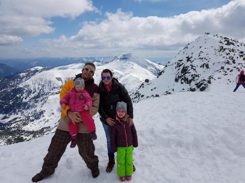 a family posing on top of a snow covered mountain at Chaty Jasná in Demanovska Dolina