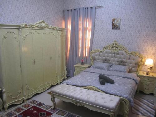 a bedroom with a large bed and a largeoire at العين الهيلي مصباح بيت 13 in Al Ain