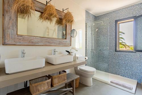 a bathroom with a sink and a toilet and a shower at Villa Charming House in La Mola