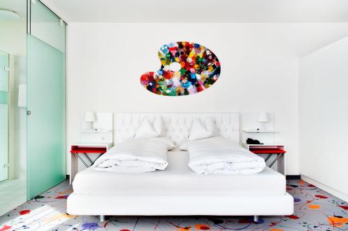 a white bed in a room with a mirror at Casinohotel Velden in Velden am Wörthersee