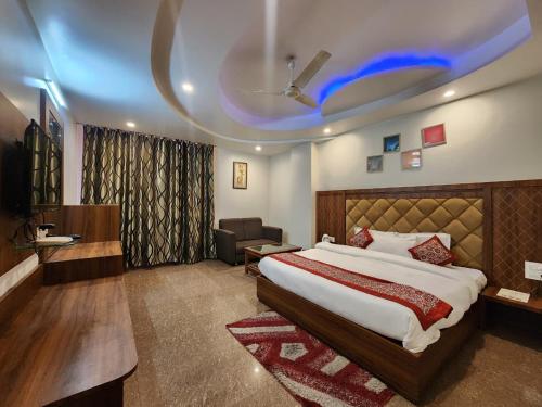 a bedroom with a large bed and a couch and a chair at Kanta International near katra railway station in Katra
