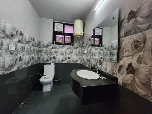 a bathroom with a toilet and a sink and a mirror at Kanta International near katra railway station in Katra