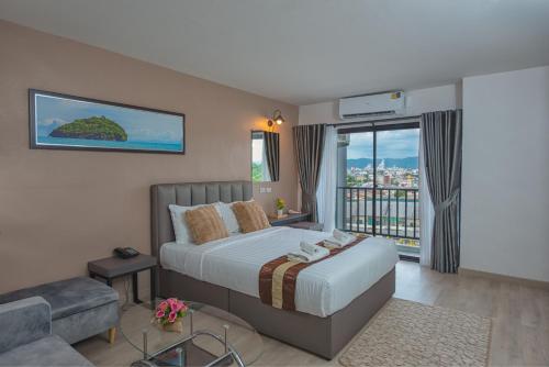 a bedroom with a large bed and a balcony at Remas Hotel Hat Yai in Ban Tha Thon