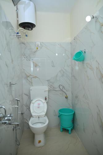 a bathroom with a toilet and a blue bucket at Hotel aditya palace in Padrauna