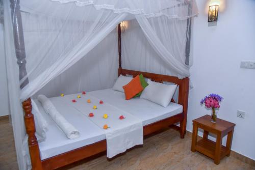 a bed in a room with a canopy at Abhimani Bungalows in Aluthgama