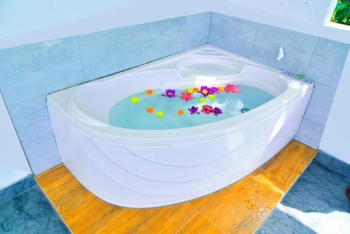 a white bath tub with flowers in the middle at Abhimani Bungalows in Aluthgama