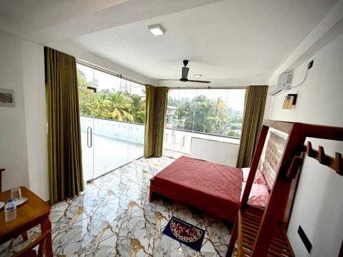 a bedroom with a bed and a large window at Sandaruwan villa in Ratgama Hegoda