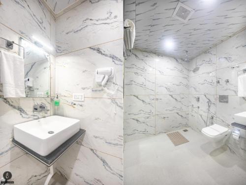 a white bathroom with a sink and a toilet at Hotel Classy Castle in Kolur