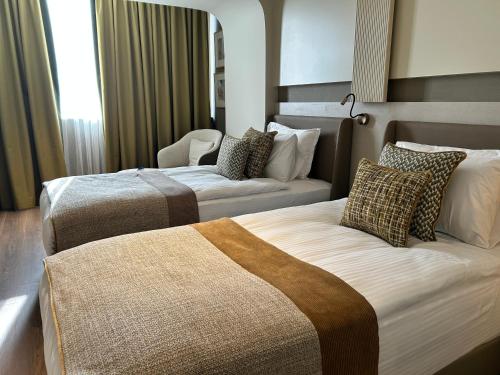 a hotel room with two beds and a couch at Buyuk Saruhan Hotel in Manisa