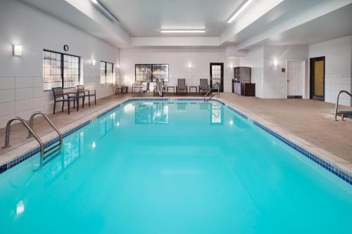 a swimming pool with blue water in a building at Staybridge Suites Lincoln North East by IHG in Lincoln