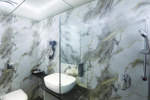 a bathroom with a sink and a glass shower at HOTEL BREEZE BAY EX - NEAR US Consulate, BKC in Mumbai