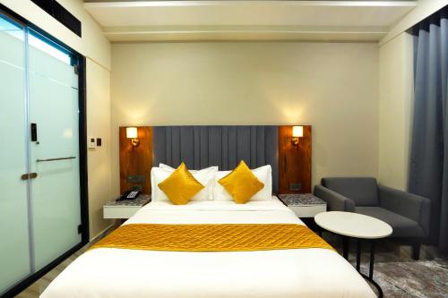 a hotel room with a large bed and a chair at HOTEL BREEZE BAY EX - NEAR US Consulate, BKC in Mumbai