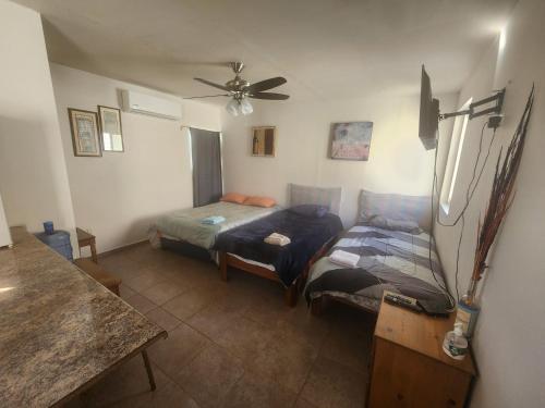 a living room with two beds and a ceiling fan at Depa Jardines Anahuac in Mexicali