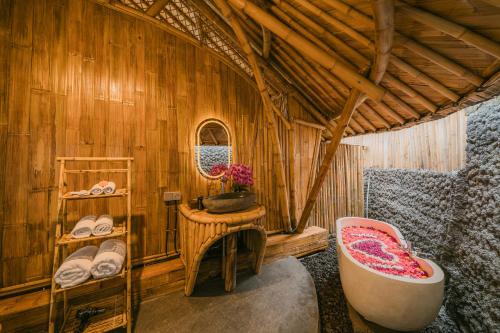 a bathroom with a bath tub and a sink at Sunrise Hill Bamboo House-Private Jungle Villa in Sidemen