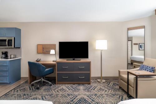 a hotel room with a tv and a desk with a chair at Candlewood Suites El Paso by IHG in Sunrise Acres