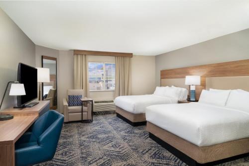 a hotel room with two beds and a television at Candlewood Suites El Paso by IHG in Sunrise Acres