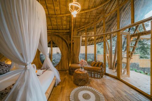 a room with a tent with a couch and a table at Sunrise Hill Bamboo House-Private Jungle Villa in Sidemen