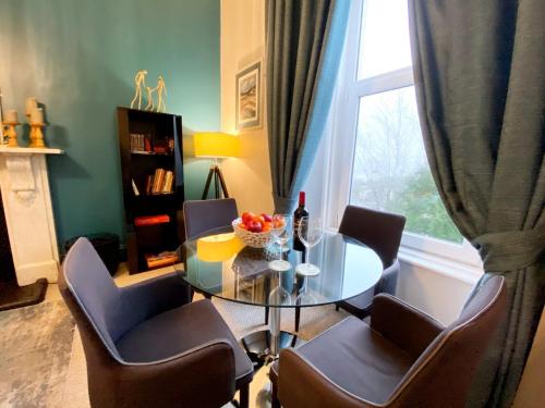 a dining room with a table and chairs and a window at 2A Redcliffe - Stunning quiet apartment by the sea in Torquay